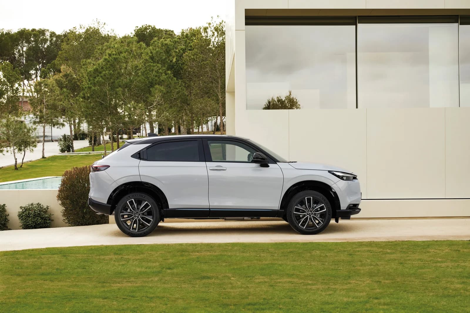 Honda HR-V — profil static, pe o alee cu iarbă, lângă o casă modernă