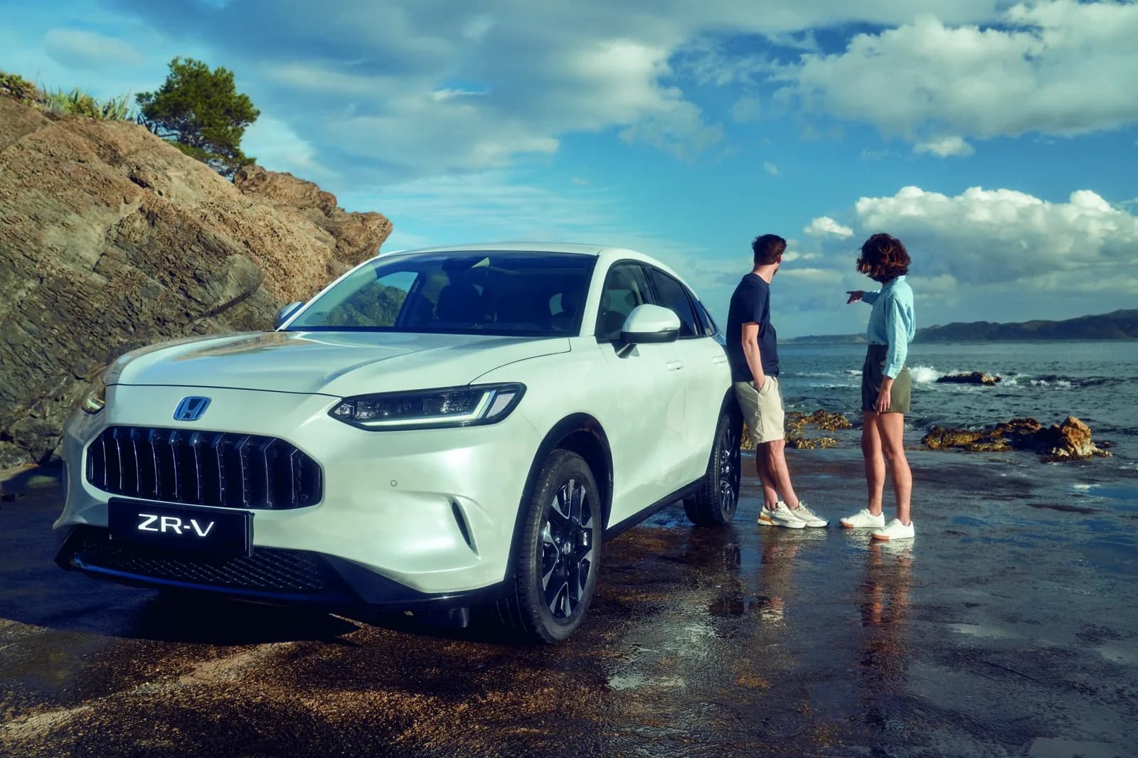 Honda ZR-V — vedere din față-lateral, pe malul apei, cu două persoane lângă mașină