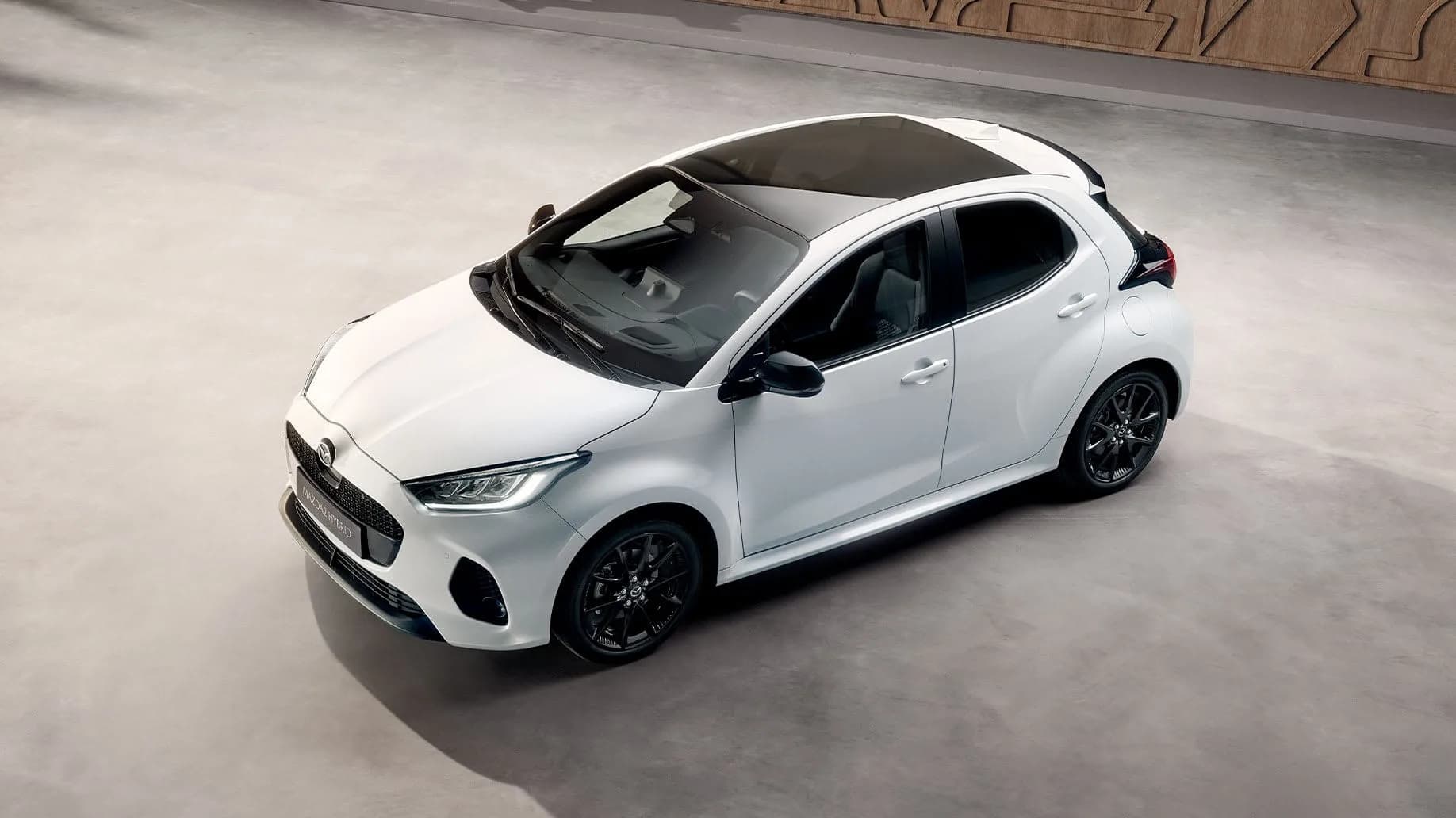 Mazda2 Hybrid albă, văzută de sus, pe o stradă din oraș