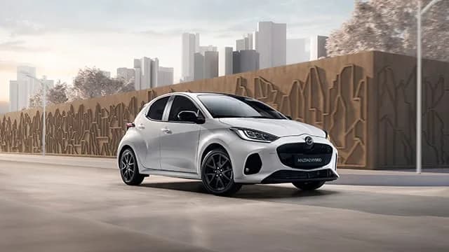 Mazda2 Hybrid — vedere din față-lateral, lângă un zid sculptat