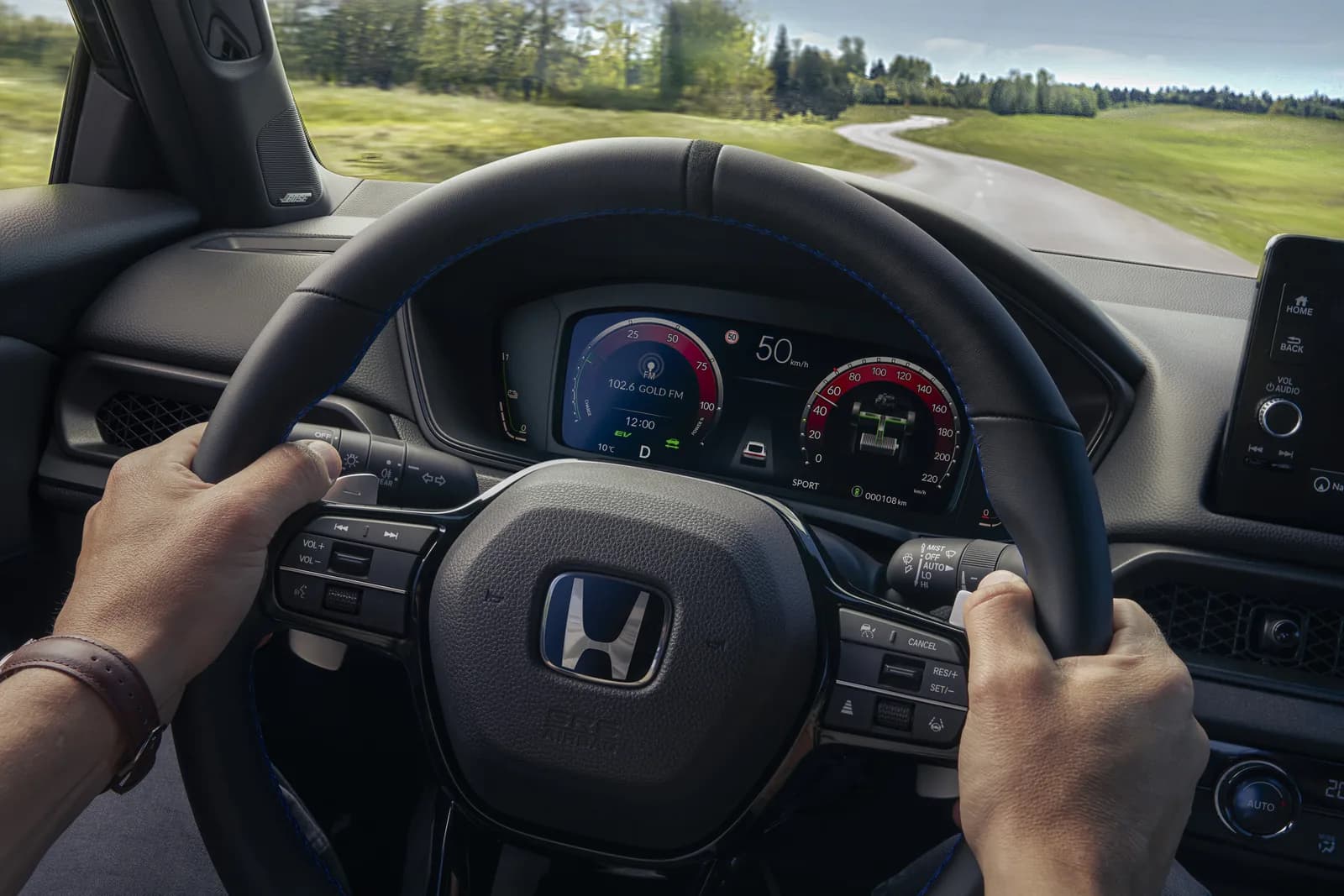 Volanul și afișajul digital al lui Honda Prelude, cu mâinile șoferului pe volan