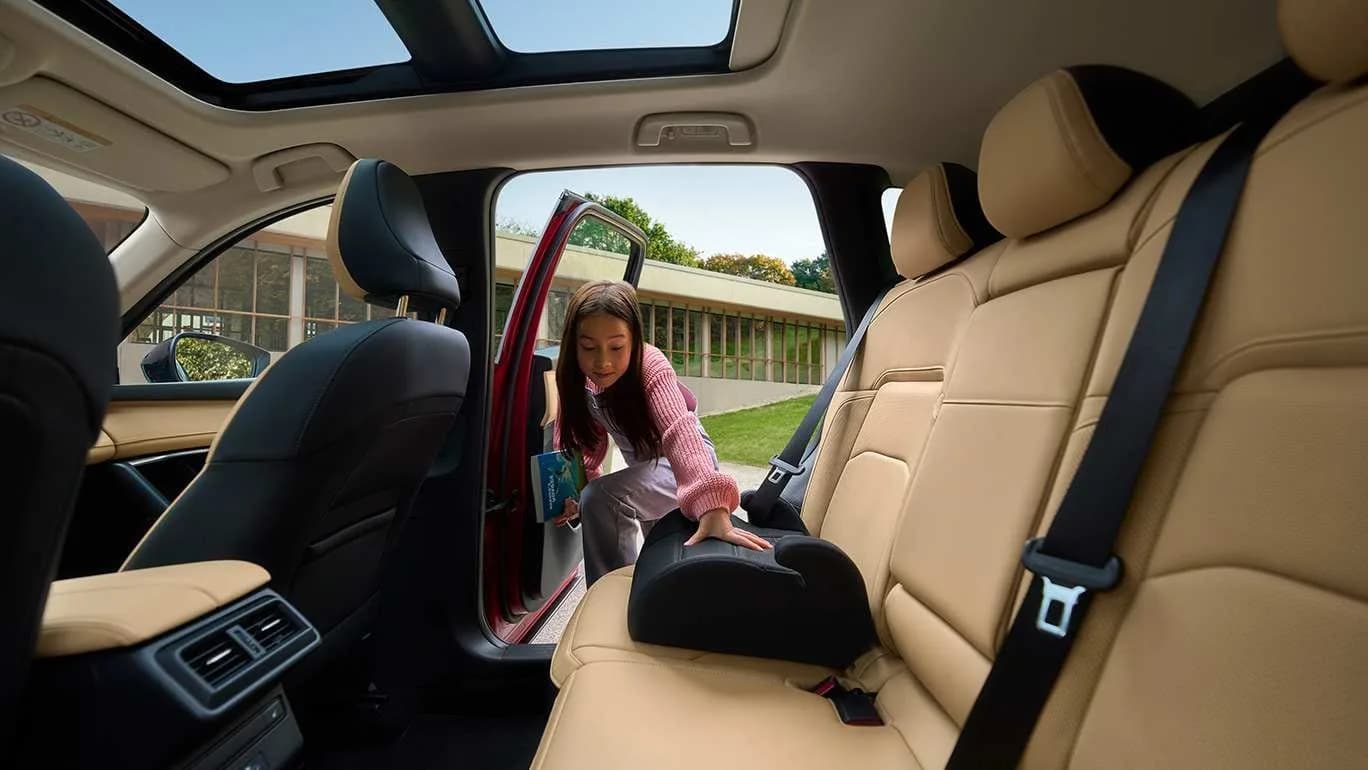 Bancheta din spate a Mazda CX-5, cu un copil urcând lângă un scaun pentru copii