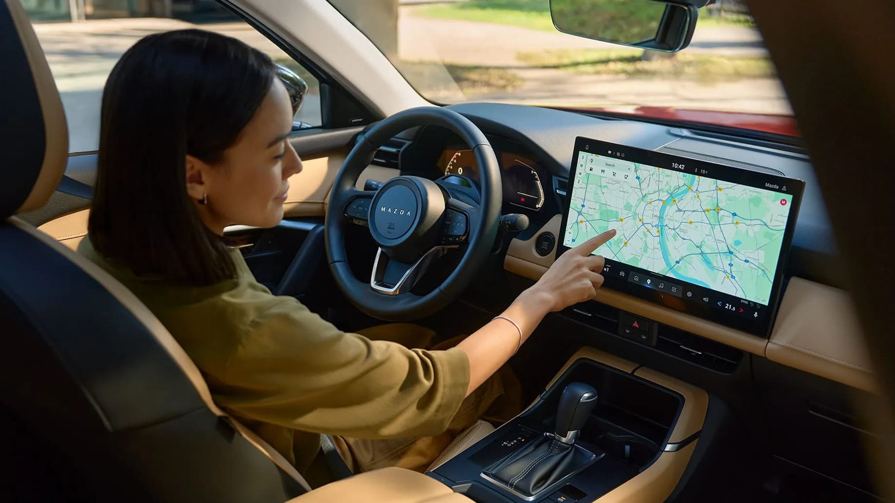 Șoferița atinge harta de pe displayul central de 12,9 inch al Mazda CX-5