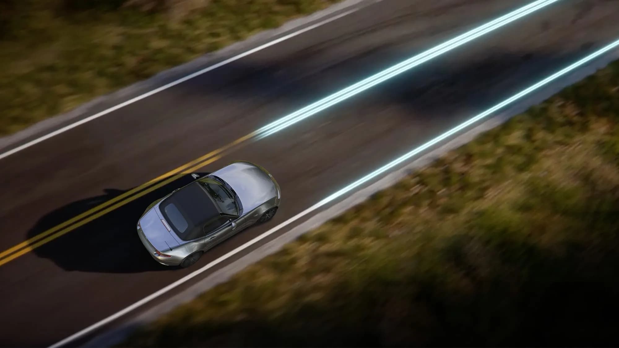 Mazda MX-5 văzută de sus, noaptea, pe un drum șerpuit