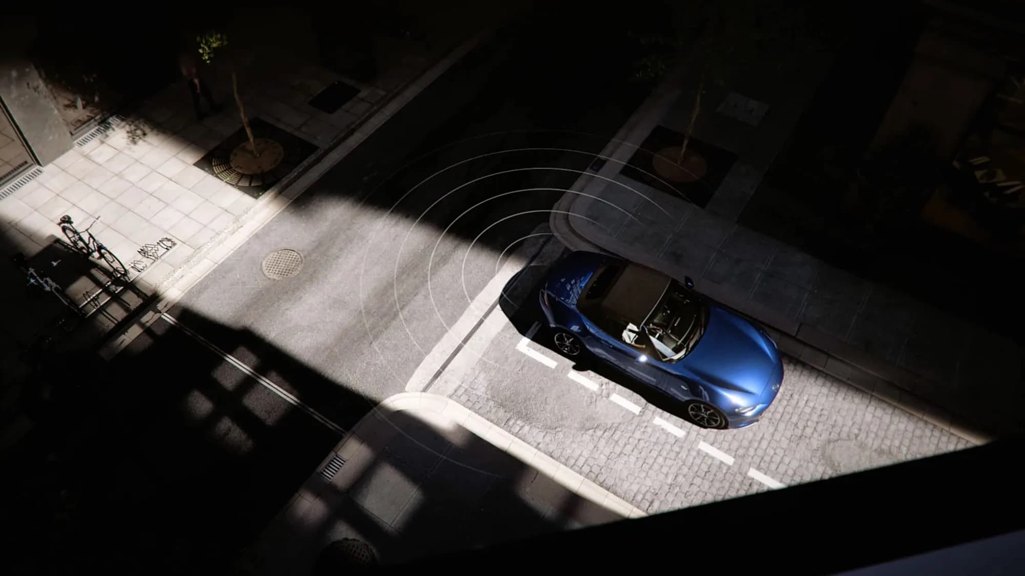 Mazda MX-5 — mașina văzută de sus într-un loc de parcare, cu undele senzorilor reprezentate grafic